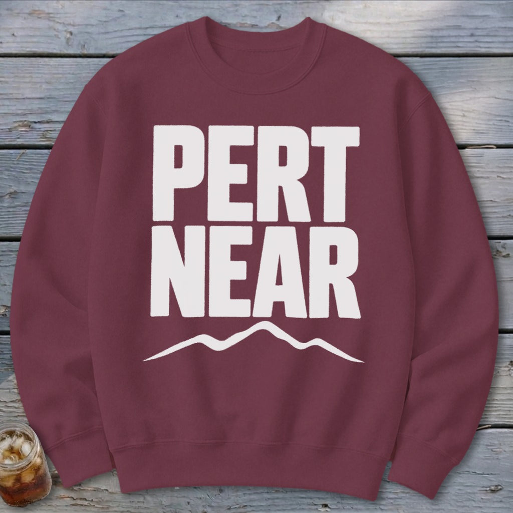 Maroon crewneck sweatshirt featuring white text that reads PERT NEAR above a simple mountain outline.