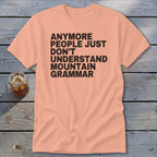 Peach t-shirt with black text that reads "Anymore people just don't understand mountain grammar."