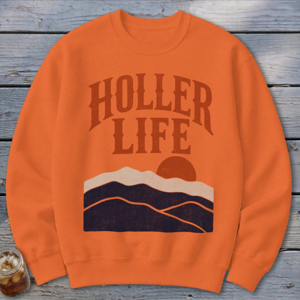 Orange crewneck sweatshirt with distressed vintage mountain graphic and the text HOLLER LIFE.