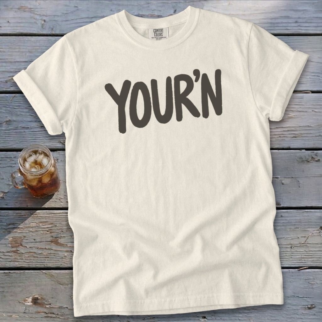 Cream Comfort Colors t-shirt with "YOUR'N" printed in dark gray.