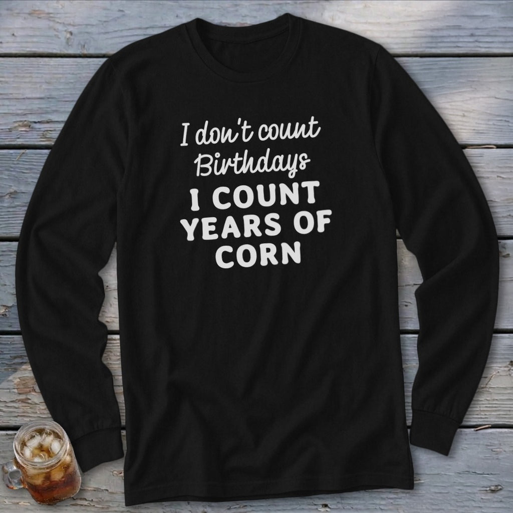 Black long-sleeve shirt with white text that says "I don't count Birthdays I COUNT YEARS OF CORN."