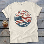Cream t-shirt with circular American flag and mountain graphic, "Star-Spangled Mountain Made" text.