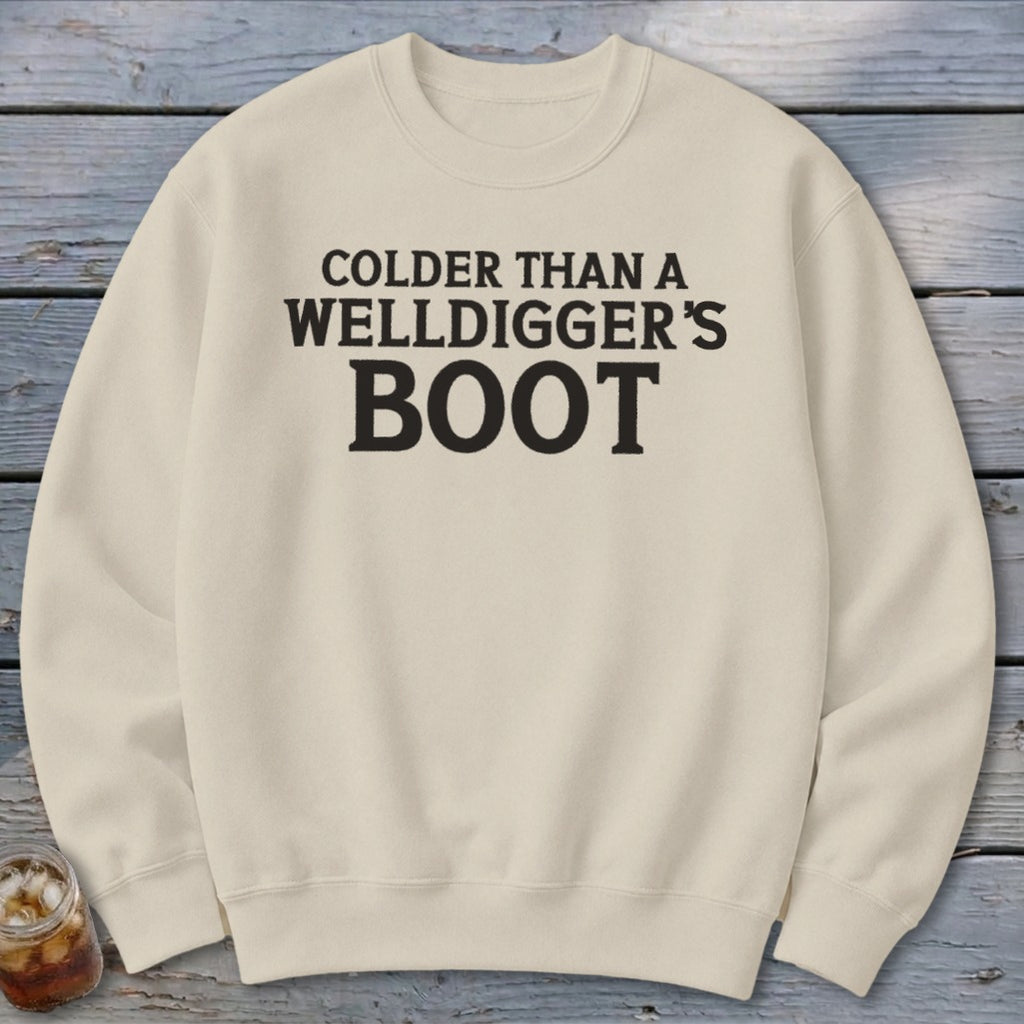 Cream sweatshirt with black text reading "Colder Than A Welldigger's Boot".