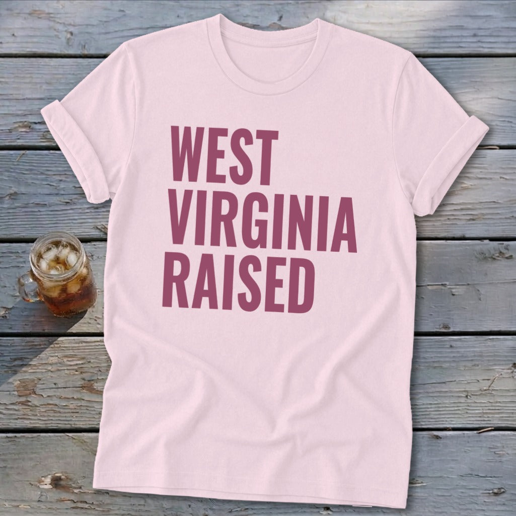 Light pink t-shirt with "WEST VIRGINIA RAISED" text in dark pink.