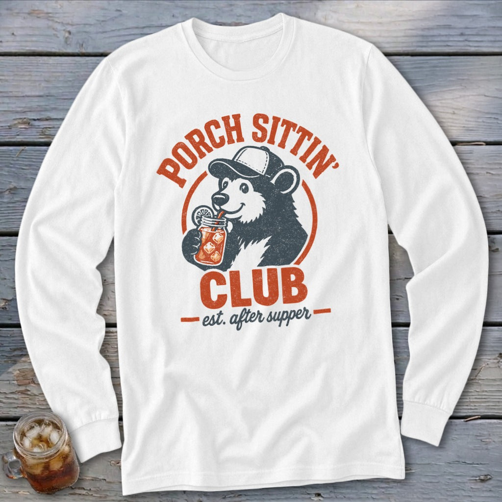 White long-sleeve shirt with a bear wearing a cap, drinking from a mason jar, and text "Porch Sittin' Club."