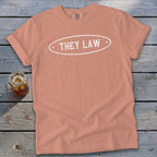 Peach t-shirt with white oval graphic reading "THEY LAW" and Comfort Colors tag.