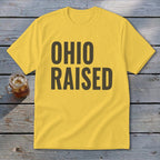 Yellow t-shirt with "OHIO RAISED" text in dark brown lettering.