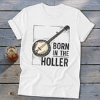 White t-shirt with banjo illustration and text "BORN IN THE HOLLER".