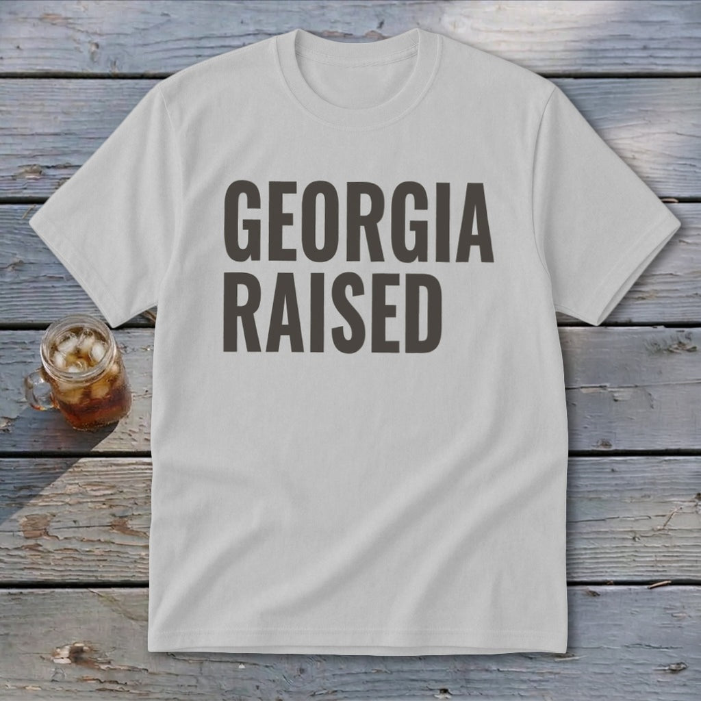 White t-shirt with bold dark gray text that reads "GEORGIA RAISED".