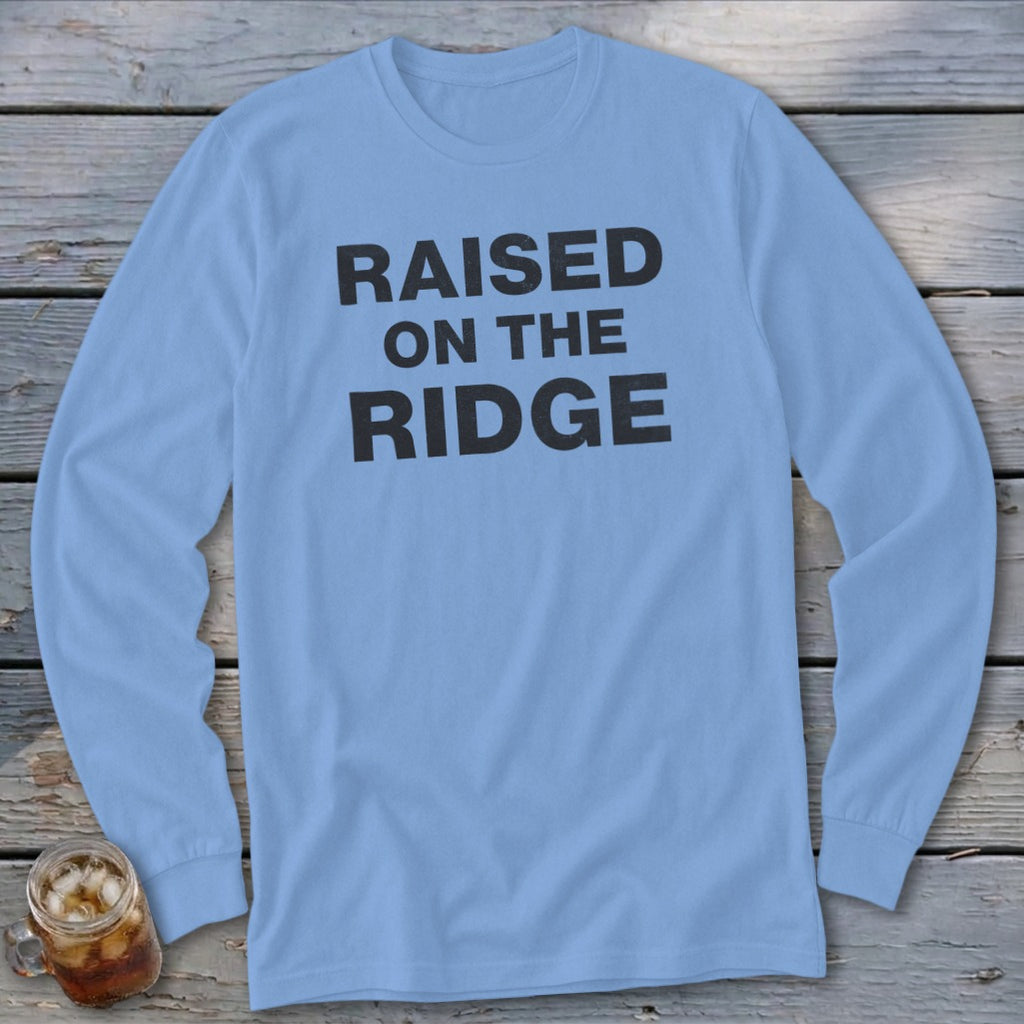 Light blue long-sleeve shirt with black text reading "RAISED ON THE RIDGE".