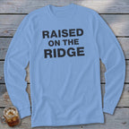 Light blue long-sleeve shirt with black text reading "RAISED ON THE RIDGE".