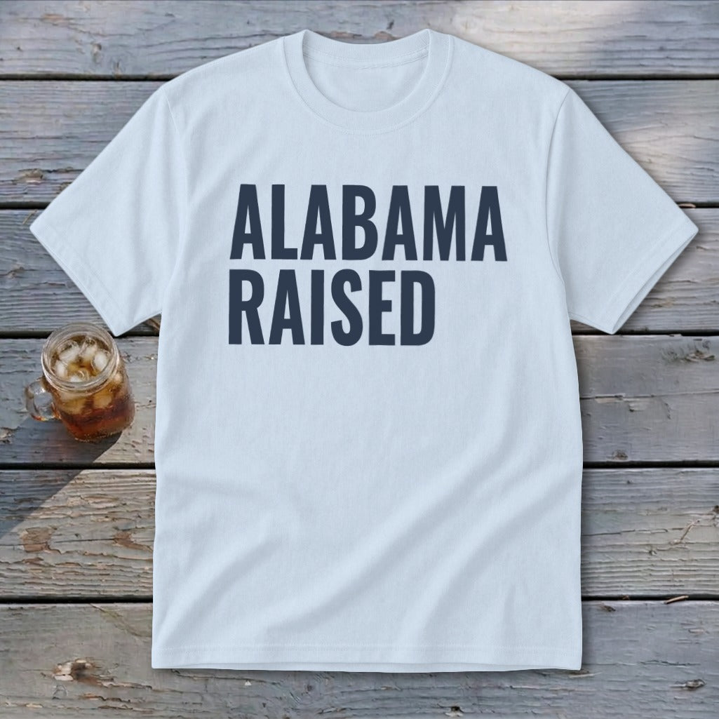 Light blue t-shirt with dark blue text that reads "ALABAMA RAISED".