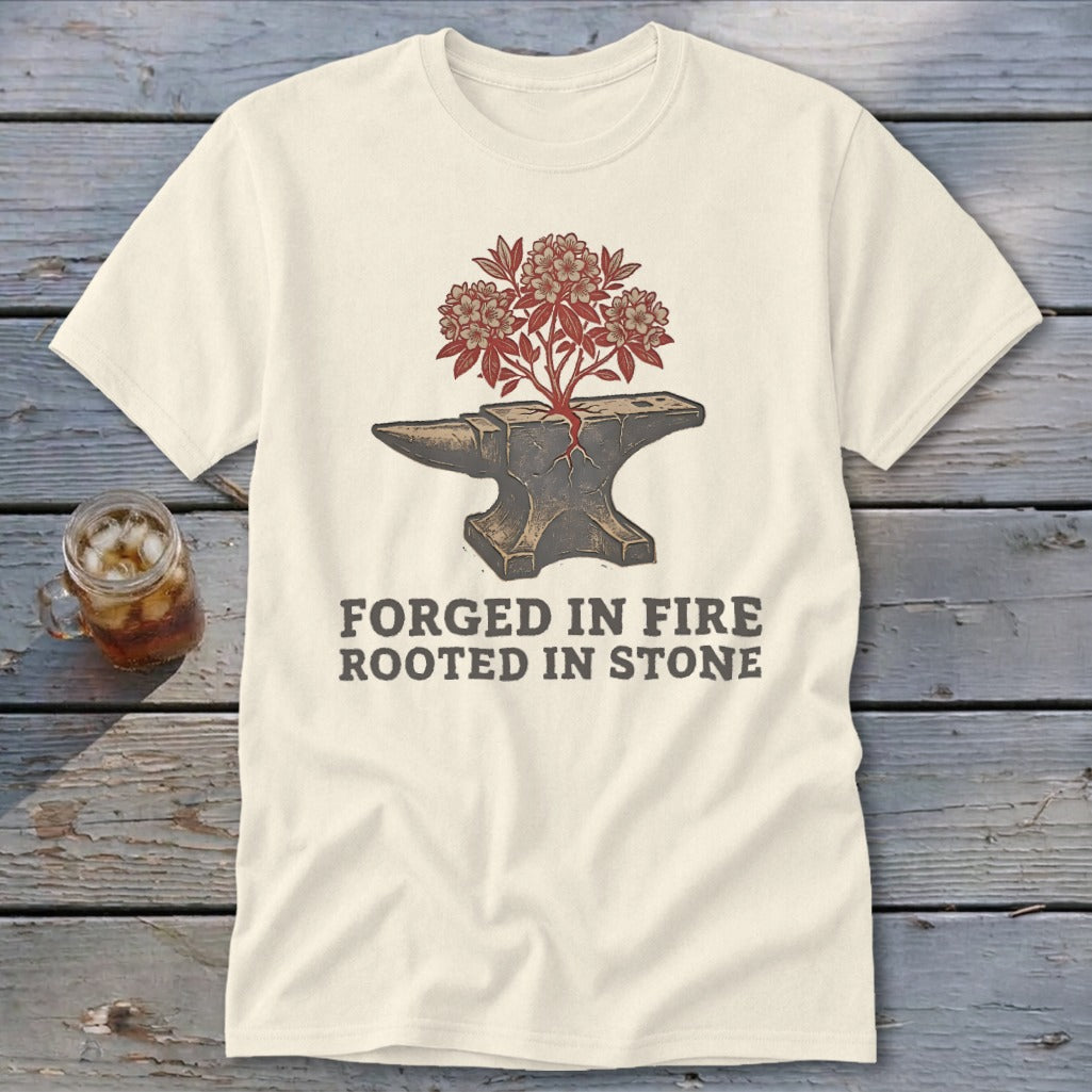 Cream t-shirt with anvil, blooming branches, and text "FORGED IN FIRE ROOTED IN STONE".
