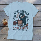 Light blue t-shirt with a bear making apple butter, text "Hollerbear Apple Butter Season".