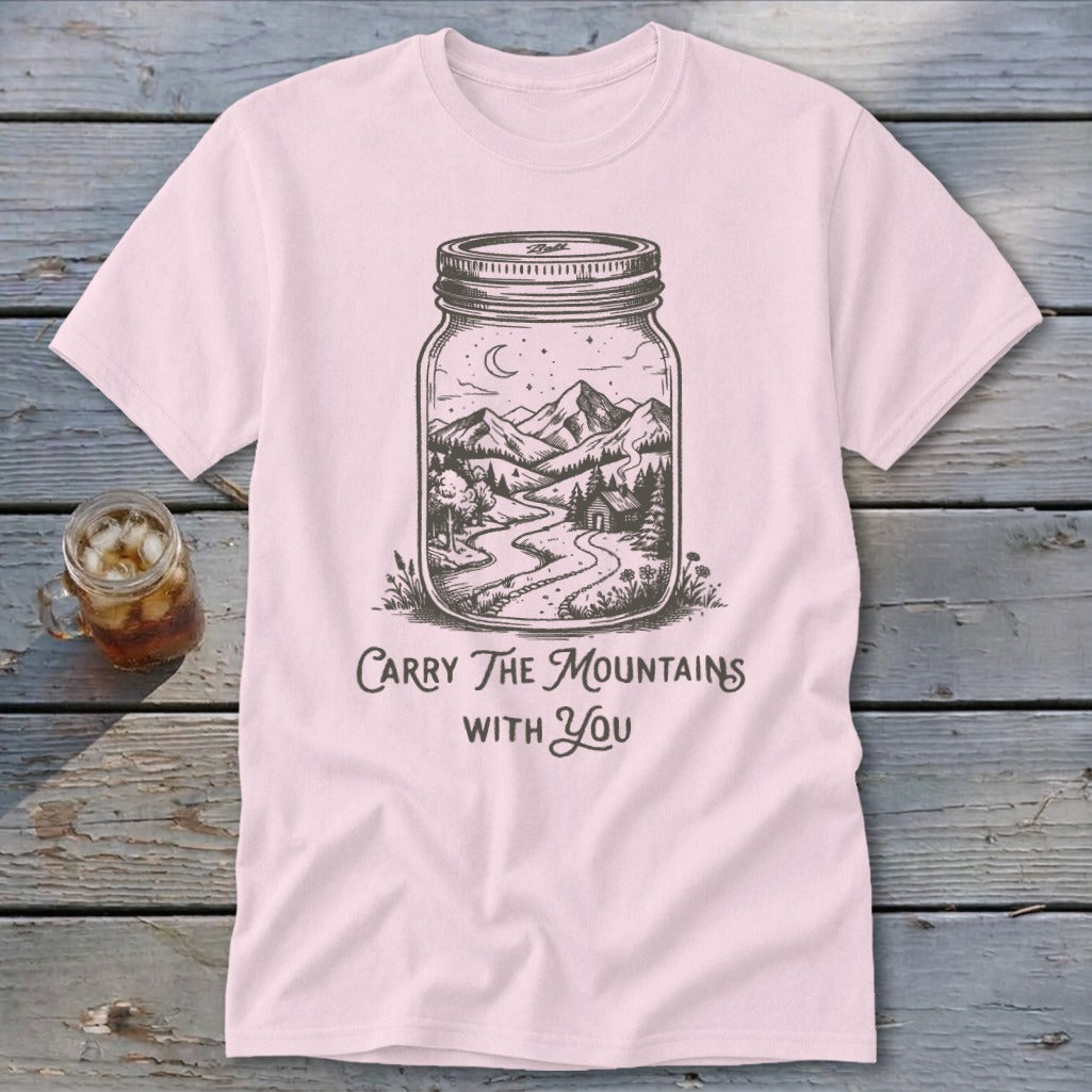 Light pink t-shirt featuring a mason jar illustration filled with a mountain landscape and text that reads Carry The Mountains With You.