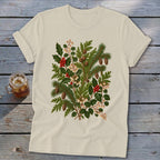 Cream t-shirt with a botanical print of pine branches, holly, berries, and pinecones.