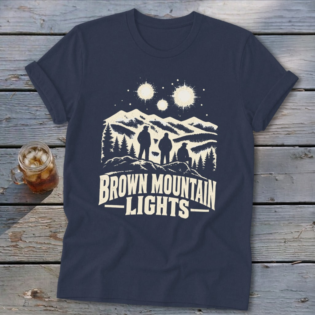 A dark blue t-shirt with a graphic of three figures looking at mountain lights.
