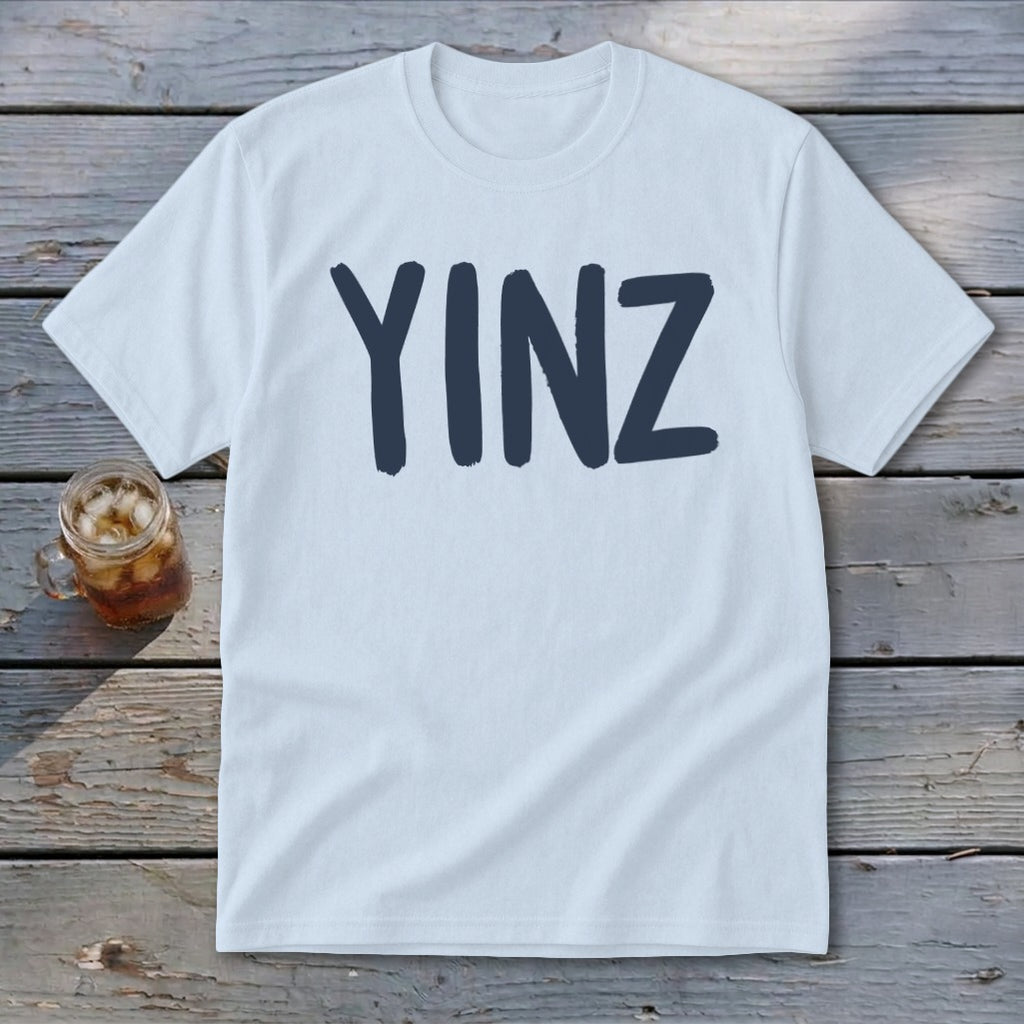 Light blue t-shirt with "YINZ" printed in dark blue, next to a glass of iced tea.