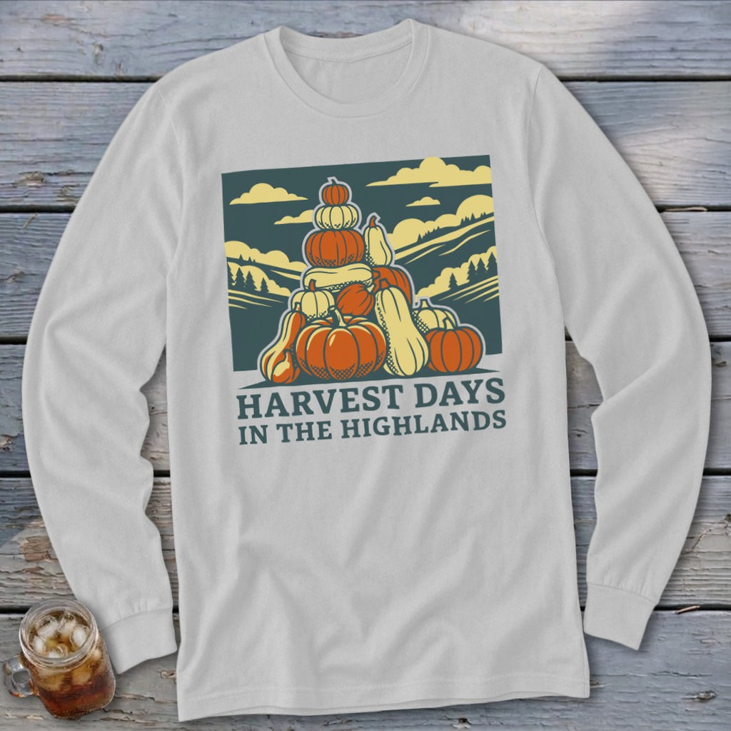 A light gray long-sleeve t-shirt features a vintage graphic of stacked pumpkins with hills and text reading Harvest Days in the Highlands.