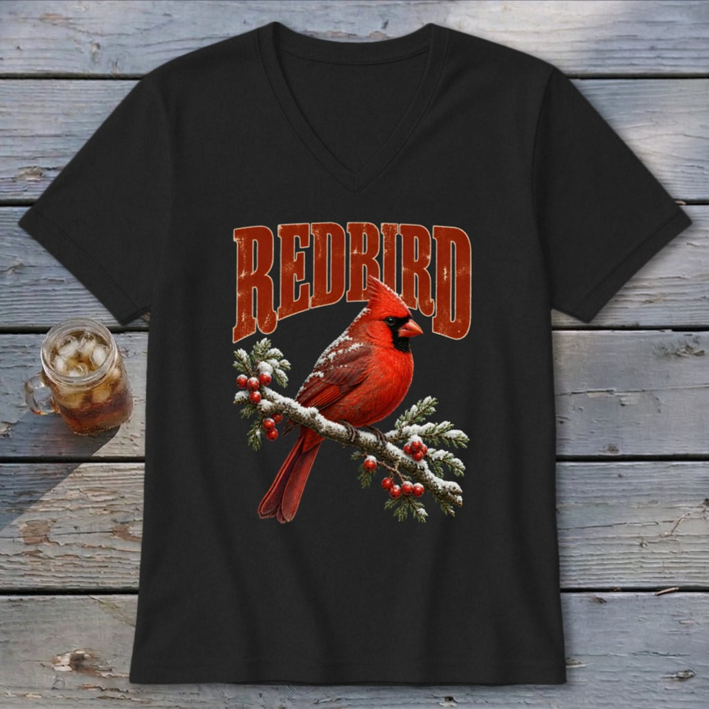 A black V-neck t-shirt features a red cardinal perched on a snow-covered pine branch with the text "REDBIRD".