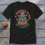 A black t-shirt featuring a green, red, and white winter beanie graphic with the text A Toboggan is for My Noggan.