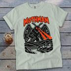 Light-colored t-shirt with black and orange Mothman graphic, featuring the creature over a town and bridge.