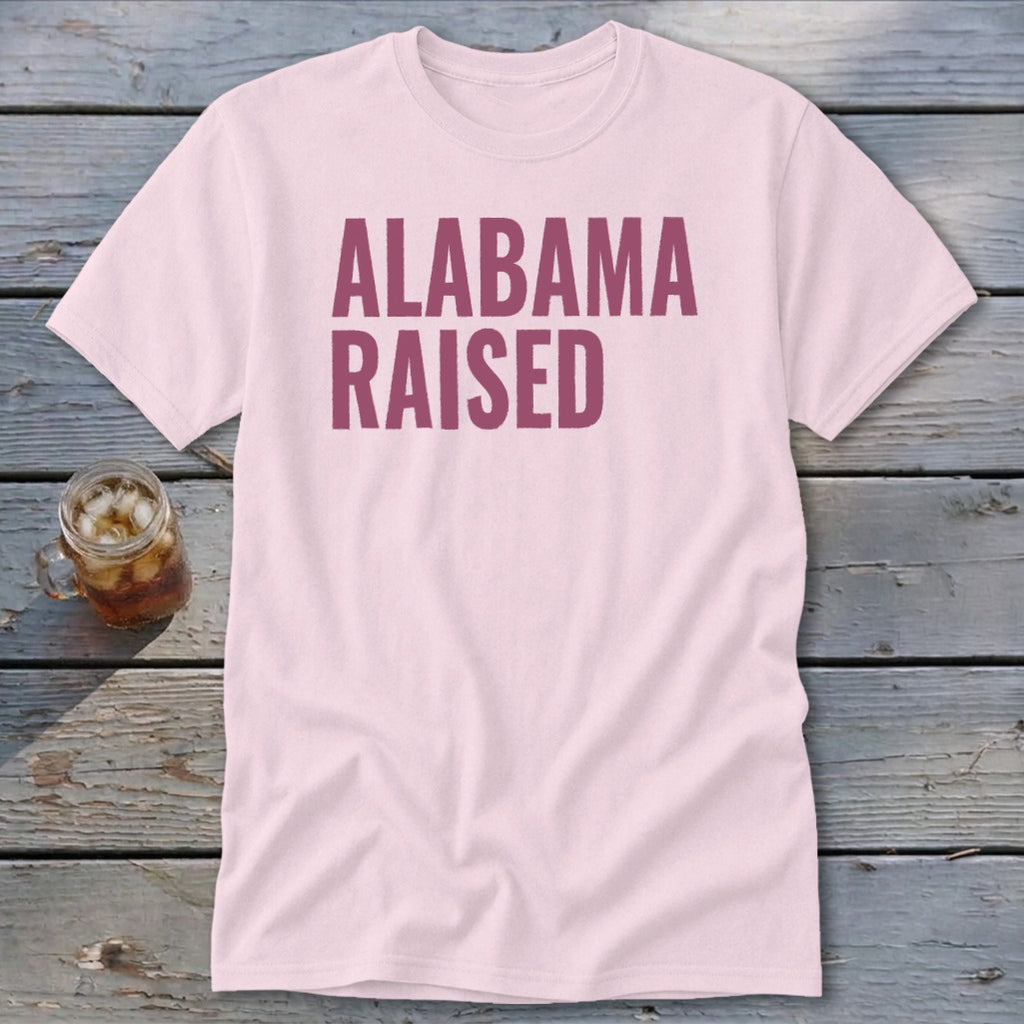 Pink t-shirt with "ALABAMA RAISED" text in maroon.