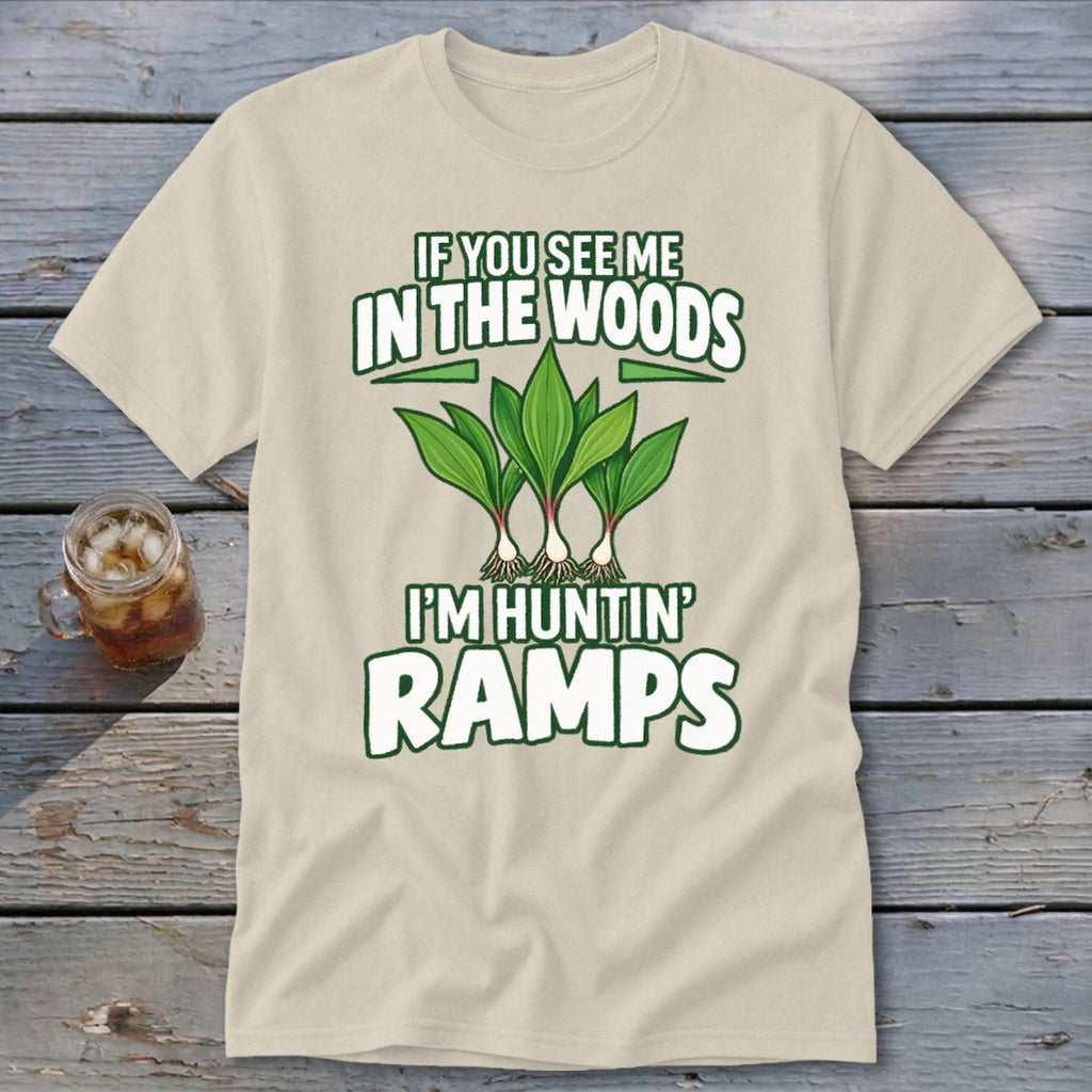 A light beige t-shirt featuring green text reading If You See Me in the Woods I'm Huntin' Ramps above an illustration of three ramp plants.