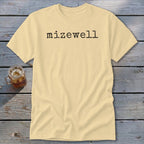 Pale yellow t-shirt with black typewriter text "mizewell" on the chest.
