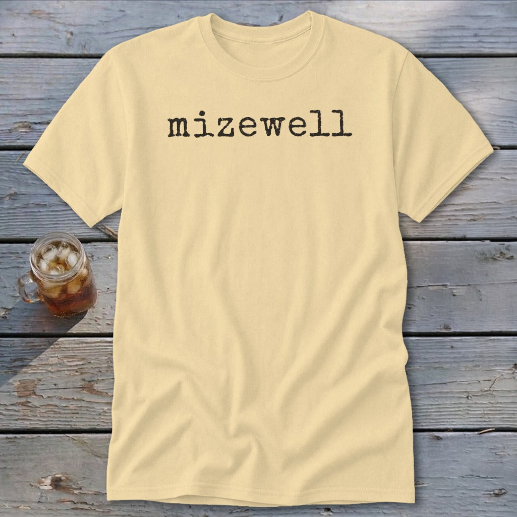 Pale yellow t-shirt with black typewriter text "mizewell" on the chest.