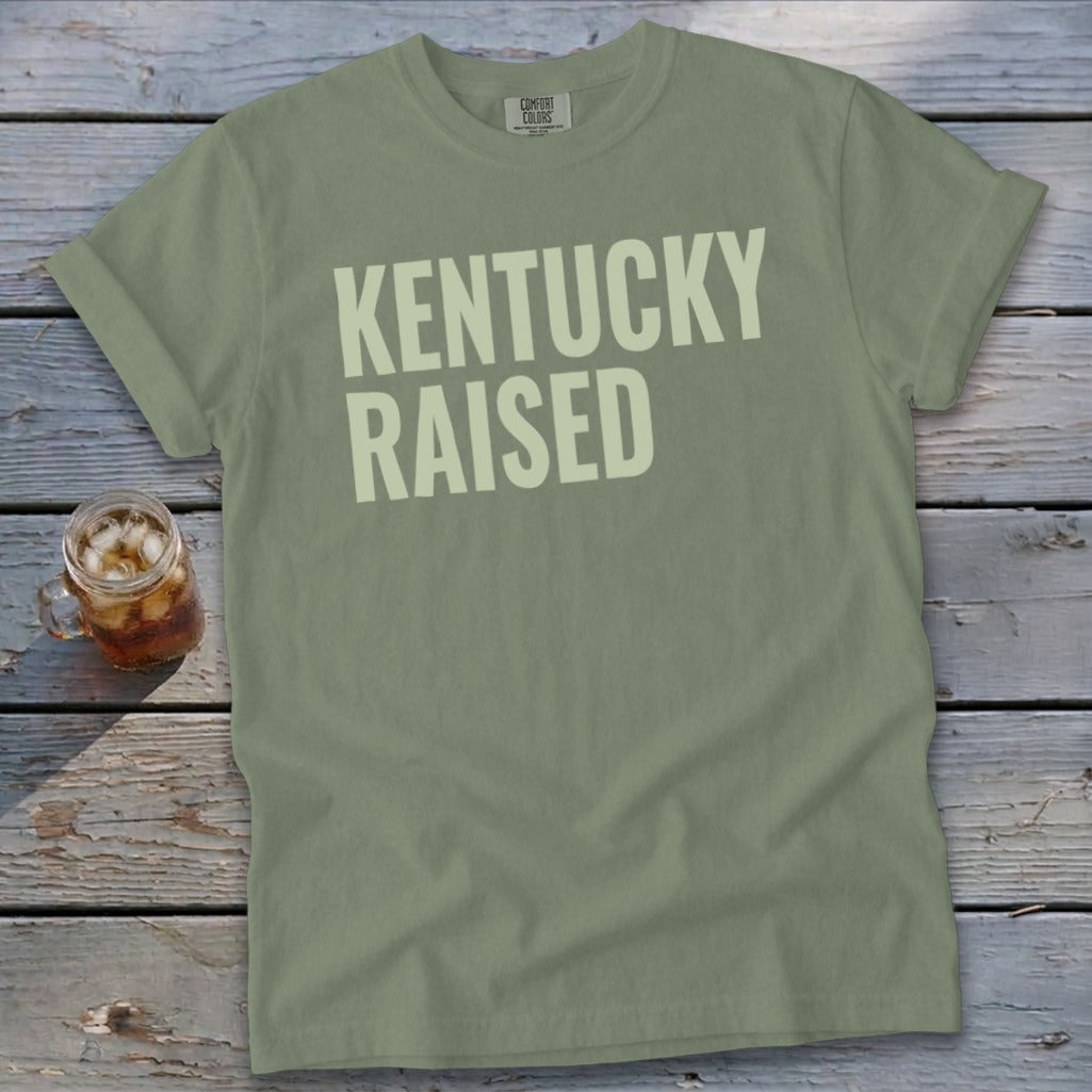 Green Comfort Colors t-shirt with "KENTUCKY RAISED" in cream text.