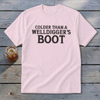 Pink t-shirt with black text reading "Colder Than A Welldigger's Boot".