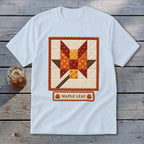Light blue t-shirt with a quilted maple leaf block design and "MAPLE LEAF" text.