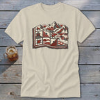A cream-colored t-shirt with a red and black graphic of a mountain landscape on the chest.