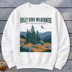 White crewneck sweatshirt featuring a graphic of Dolly Sods Wilderness with pine trees and a flying bird.