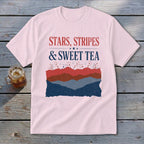 Light pink t-shirt featuring the text "Stars, Stripes & Sweet Tea" above layered red, brown, and blue graphics.