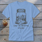 Light blue crewneck t-shirt featuring a mason jar illustration of mountains and the text Carry The Mountains With You.