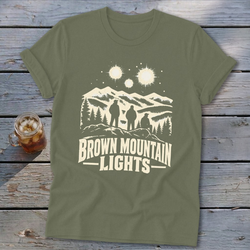 Olive green crewneck t-shirt featuring a graphic of three figures, mountains, stars, and the text Brown Mountain Lights.