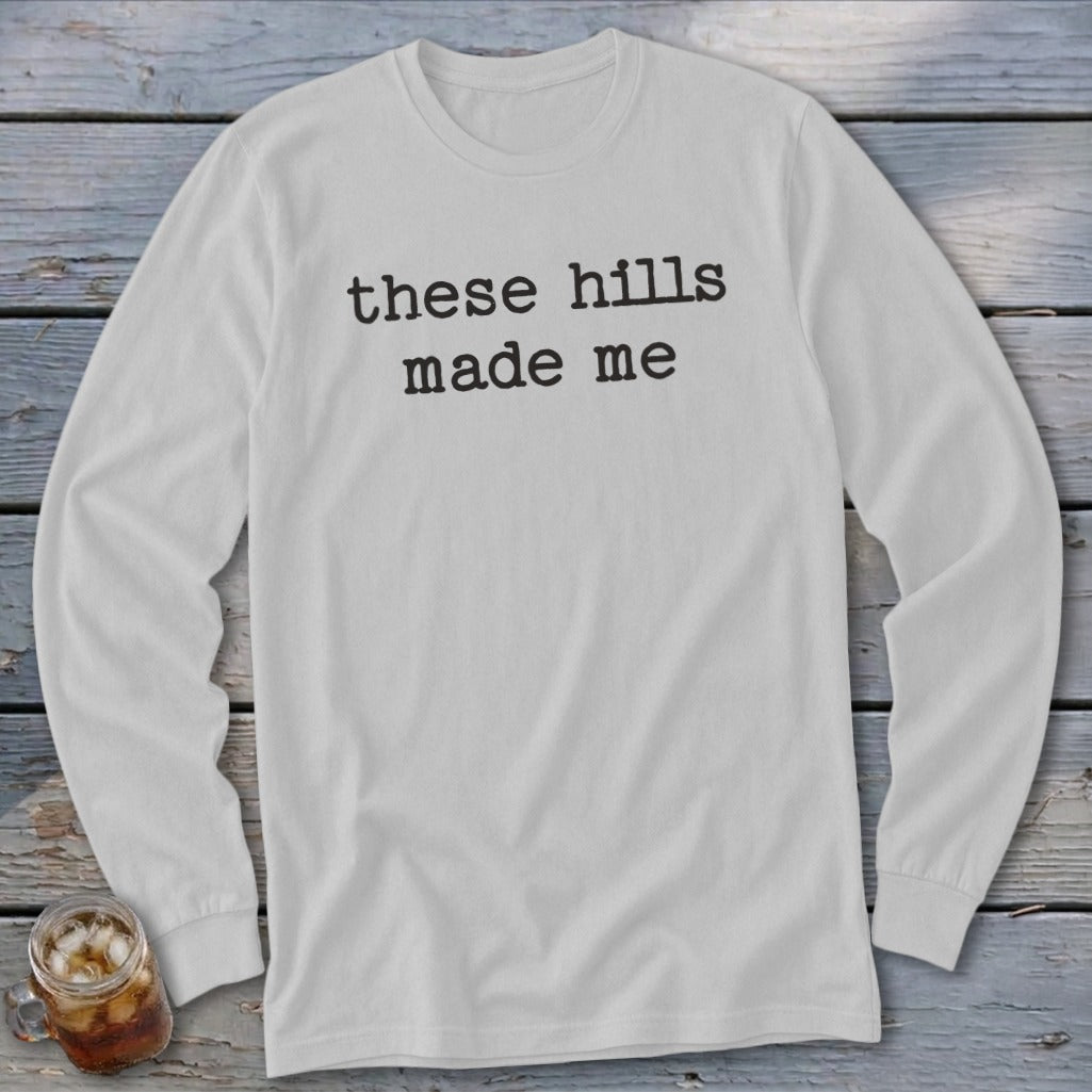 White long-sleeve shirt with black text "these hills made me".