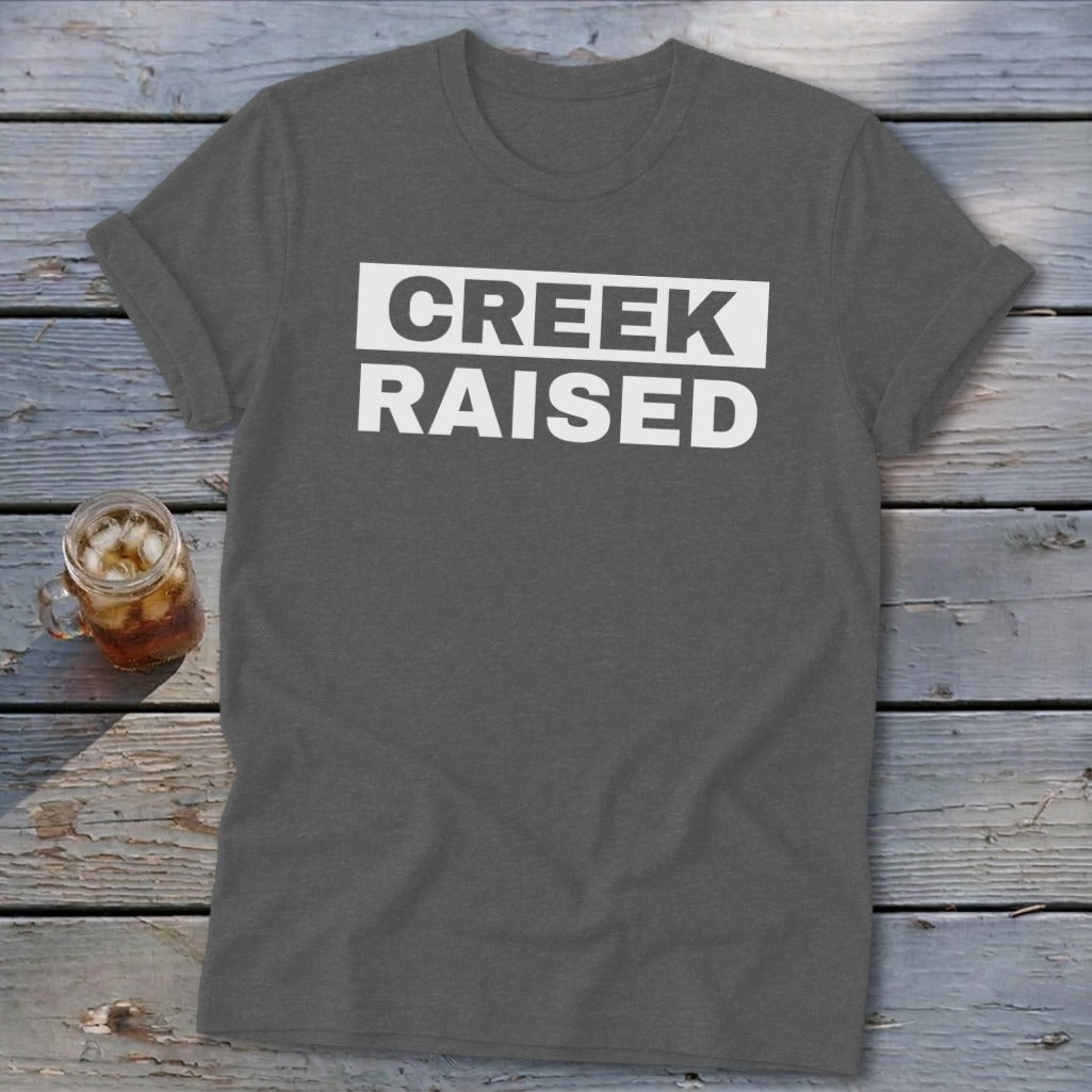 Dark grey t-shirt with white text that reads "CREEK RAISED".