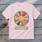 Pink t-shirt with a Dresden Plate quilt-style flower graphic and text.