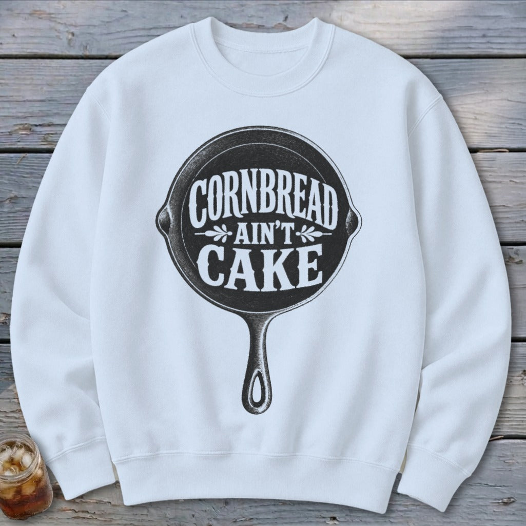 White sweatshirt with "Cornbread Ain't Cake" in a skillet graphic.