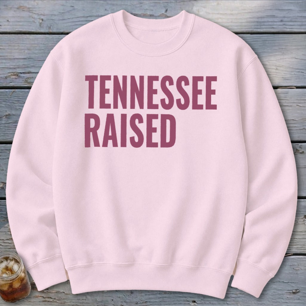 Pink sweatshirt with maroon text that reads "TENNESSEE RAISED".