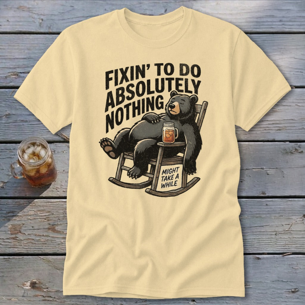 A pale yellow t-shirt with a graphic of a bear relaxing in a rocking chair.