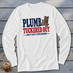White long-sleeve shirt with "PLUMB TUCKERED OUT AND IT AIN'T EVEN DINNER" text.