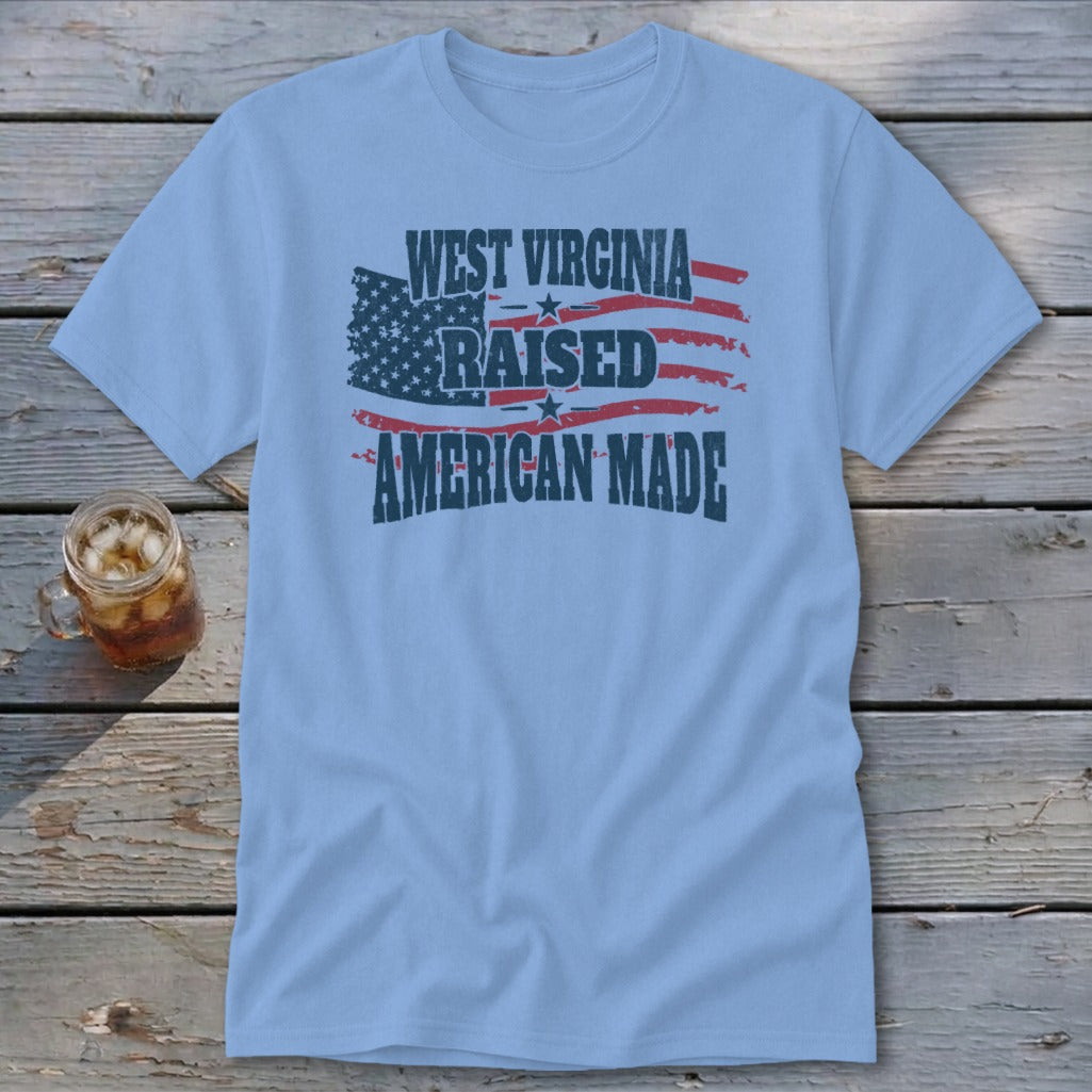 Light blue t-shirt featuring a distressed American flag and text that reads West Virginia Raised American Made.
