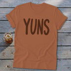 Brown text "YUNS" on a rust-colored t-shirt with a drink.