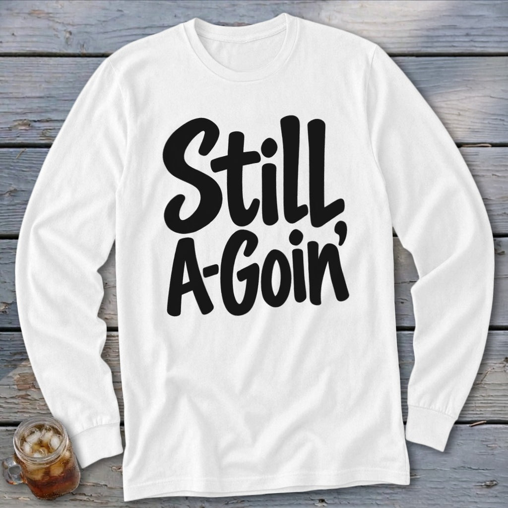 White long-sleeve t-shirt with black cursive text reading Still A-Goin centered on the chest.