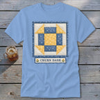 Light blue t-shirt with a Churn Dash quilt block design and "CHURN DASH" text.
