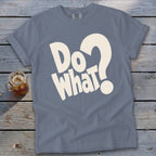 A blue t-shirt featuring the white text "Do what?" on a wooden background with a glass drink.